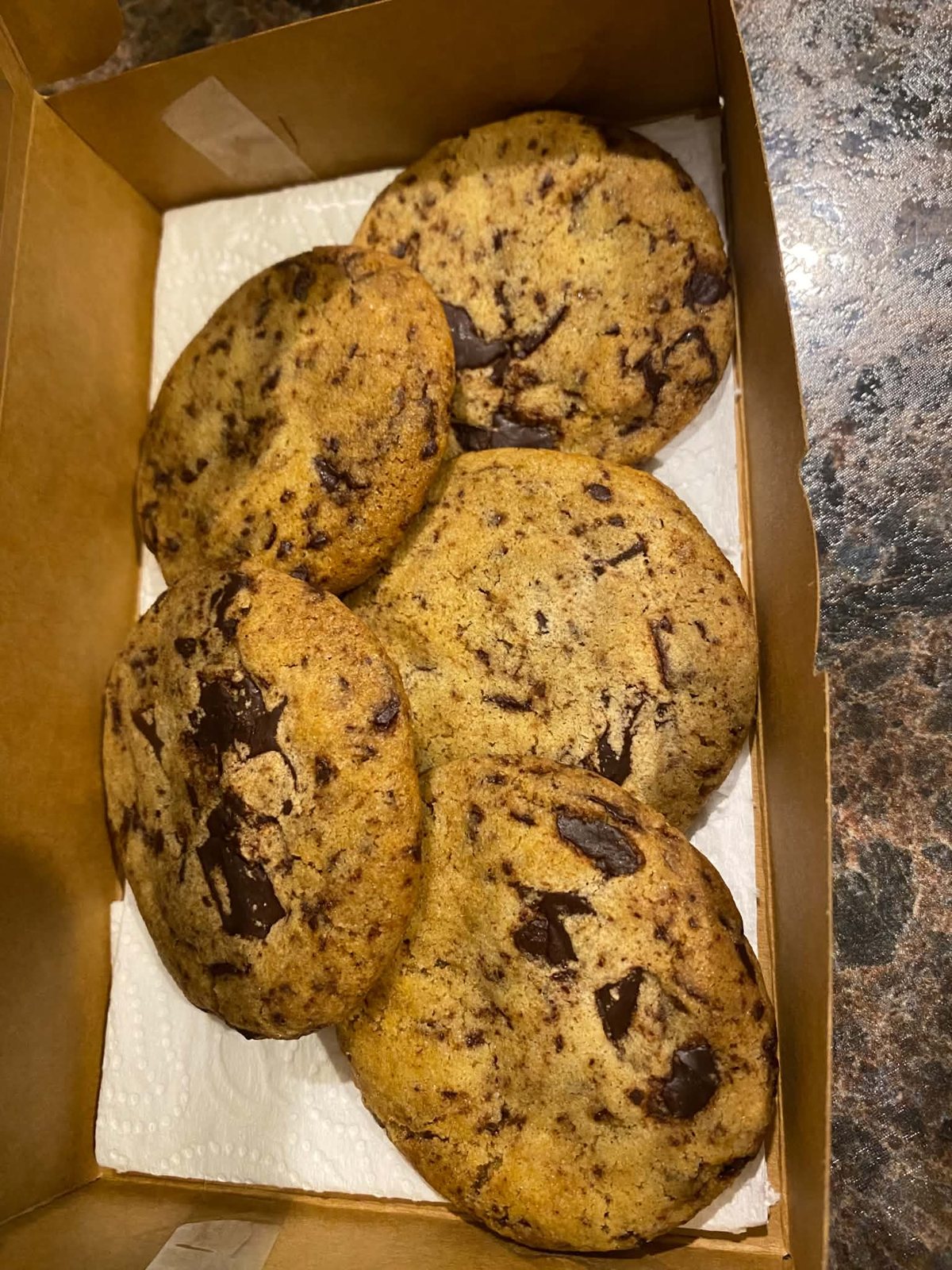 Cookies with visible chocolate pieces arranged in a baking box.